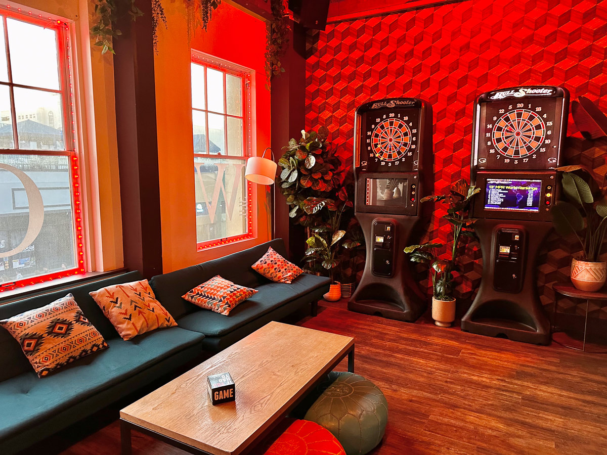 couches and dart games with red lighting